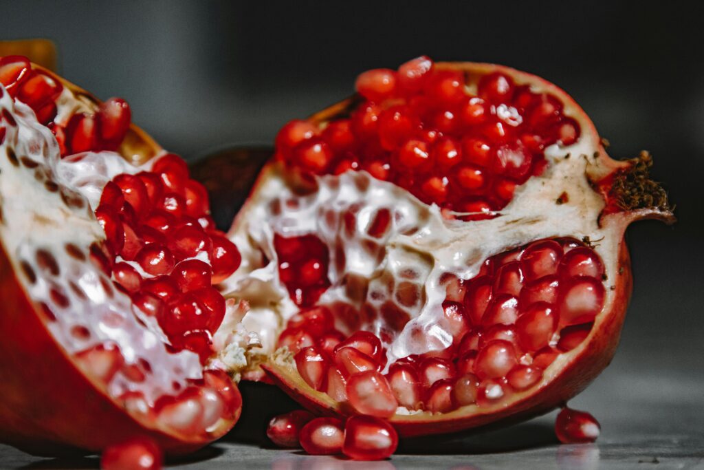 A close-up shot of a juicy pomegranate revealing vibrant red seeds and textured skin.